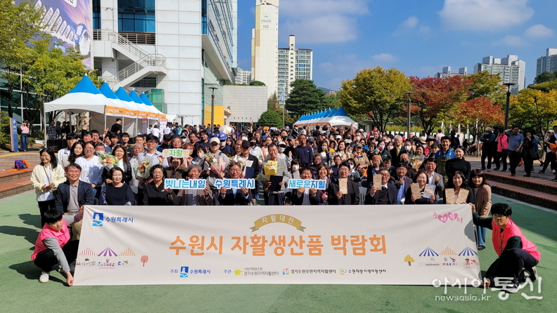 수원시 자활 생산품 박람회 참석자들이 단체 사진을 촬영하고 있다