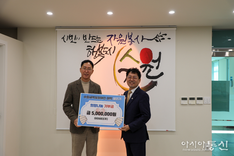 정종각(왼쪽) 아이비티㈜ 대표이사가 김상연(오른쪽) 수원경실련 공동대표에 수원새벽빛 장애인야학 살리기에 기부금 500만 원을 전달하고 있다.