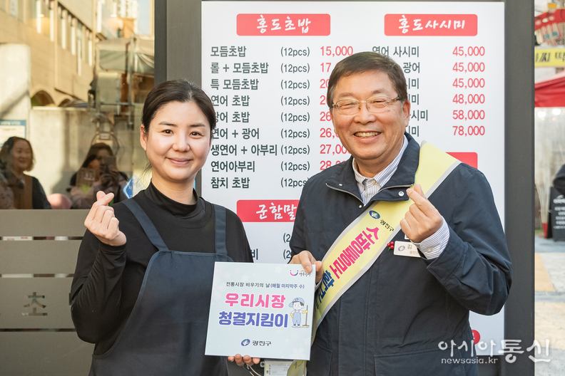 김경호 구청장이 홍보초밥 대표 권승희씨에게 청결지킴이 표지판 전달하는 모습