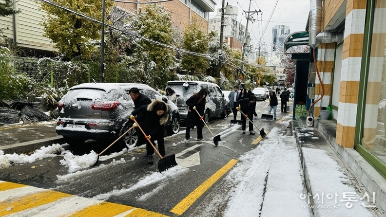 직원들이 아침 일찍부터 도로, 보도에 쌓인 눈을 치우고 있다.
