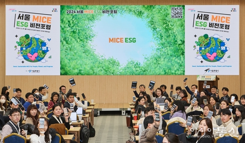 참가자들이 서울 MICE ESG 가이드라인을 모바일로 다운받아 손들고 있는 모습
