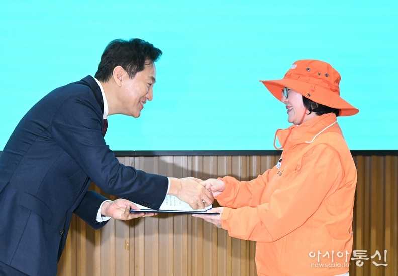 오세훈 서울시장이 14일(금) 오전 서울시청 다목적홀에서 열린 '제6기 디지털안내사 발대식'에서 안내사 대표에게 위촉장을 수여하고 있다.