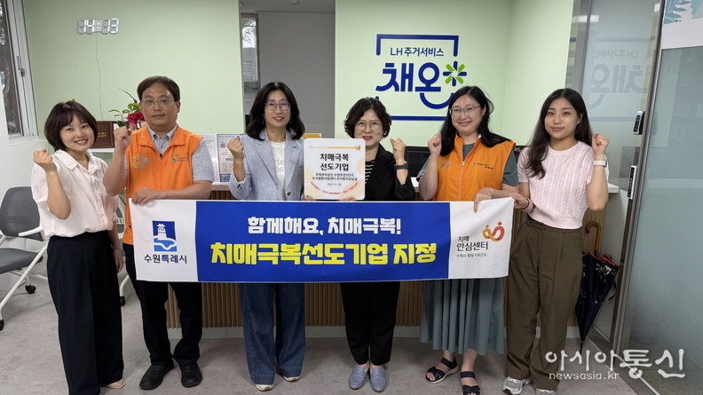 팔달구 치매안심센터 관계자가 현판을 전달하고 기념사진을 촬영하고 있다.