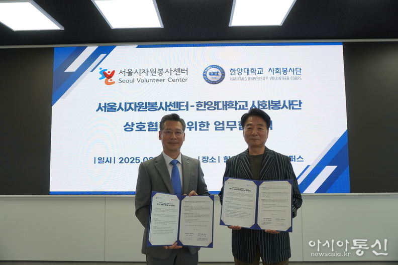 (왼쪽) 한양대학교 사회봉사단 김민수 단장, (오른쪽) 서울시자원봉사센터 송창훈 센터장이 협약서를 들고 기념촬영을 하고 있다.