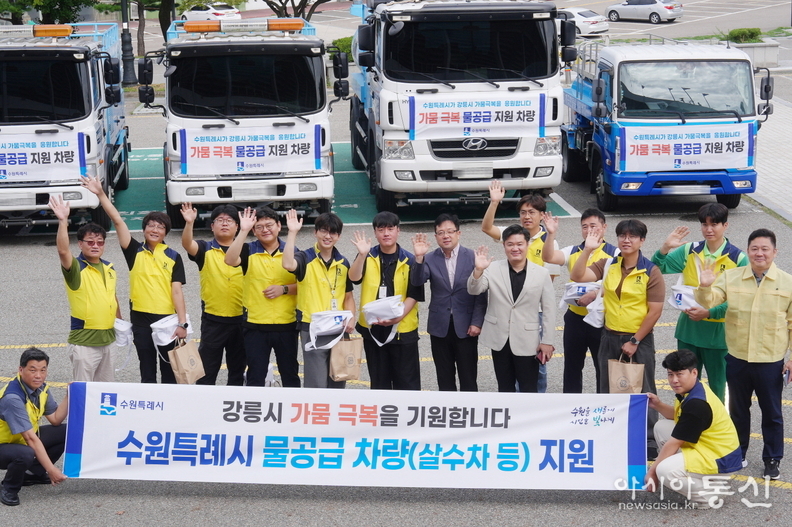 김현수 제1부시장과 수원시 관계자들이 강릉시 물 공급 지원차량 앞에서 함께하고 있다.
