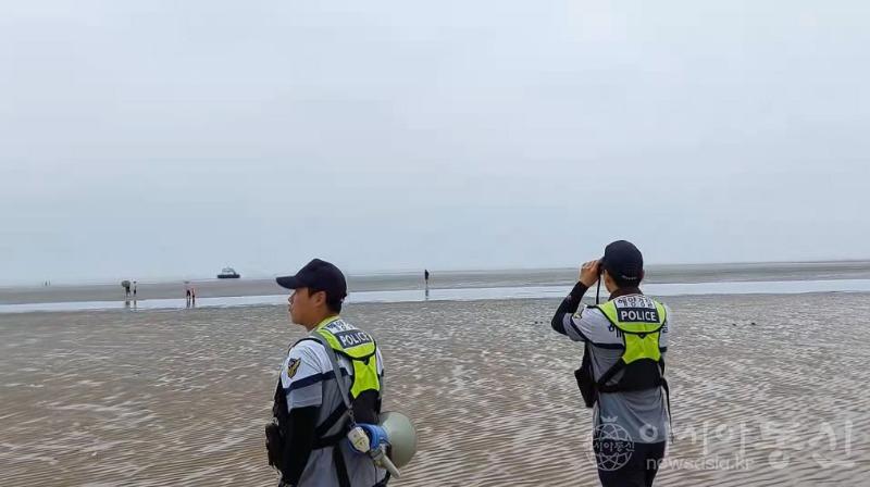 인천해양경찰서 하늘바다파출소 경찰관들이 하나개해수욕장에서 안전계도활동을 하고 있는 모습..jpg