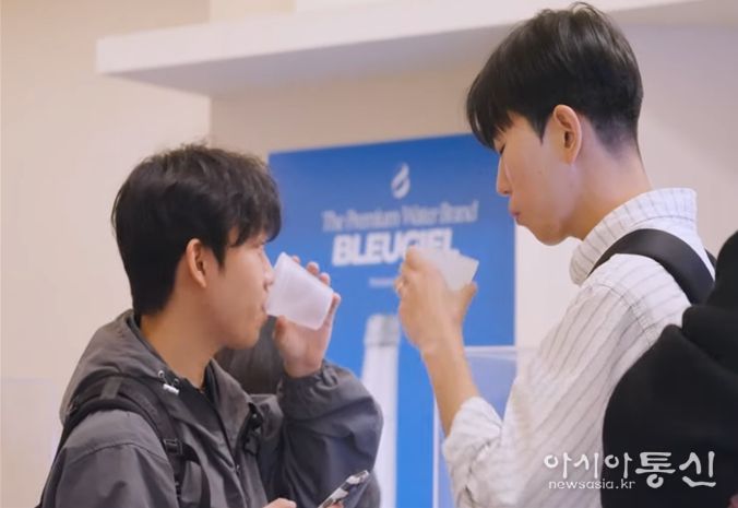 팝업 시음회에서 물을 마셔보는 사람들