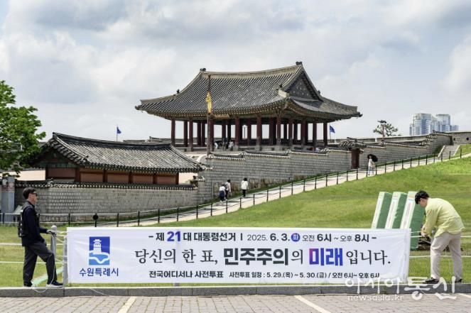 투표 참여를 독려하는 문구가 적힌 현수막을 설치하고 있다.