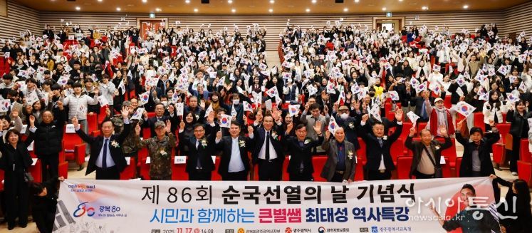 광주시교육감 이정선이 17일 광주광역시교육청교육연수원 대강당에서 열린 ‘광복 80주년, 제86회 순국선열의 날 기념식’에서 태극기를 흔들며 기념사진을 촬영하고 있다.